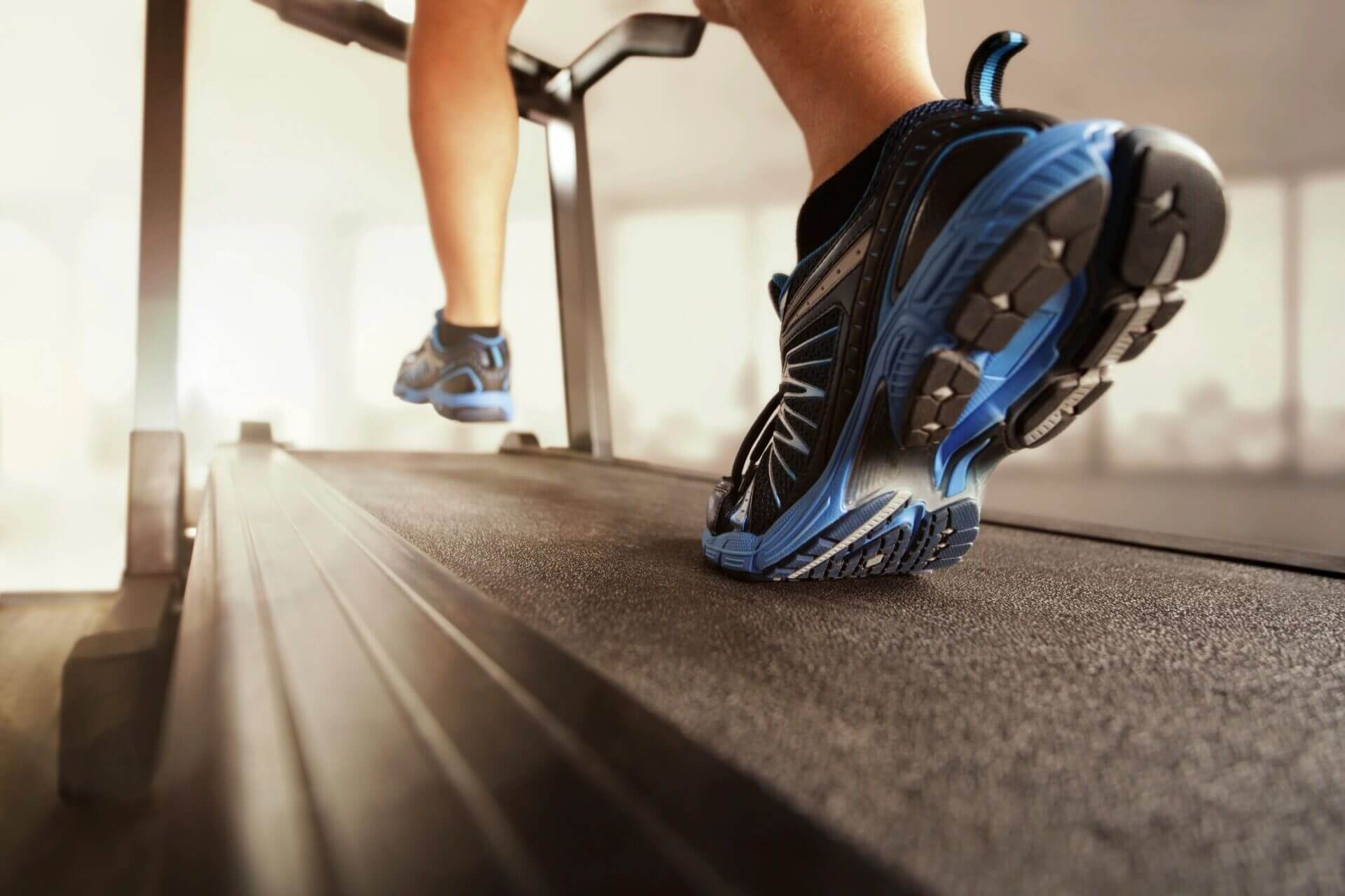 Close-up of blue running shoes on treadmill