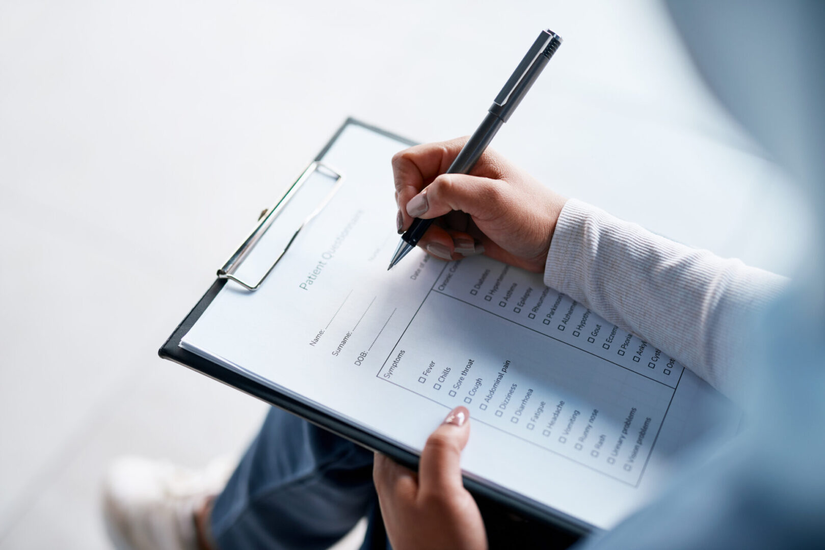 Person filling out a patient questionnaire form. Person filling out a patient questionnaire form.