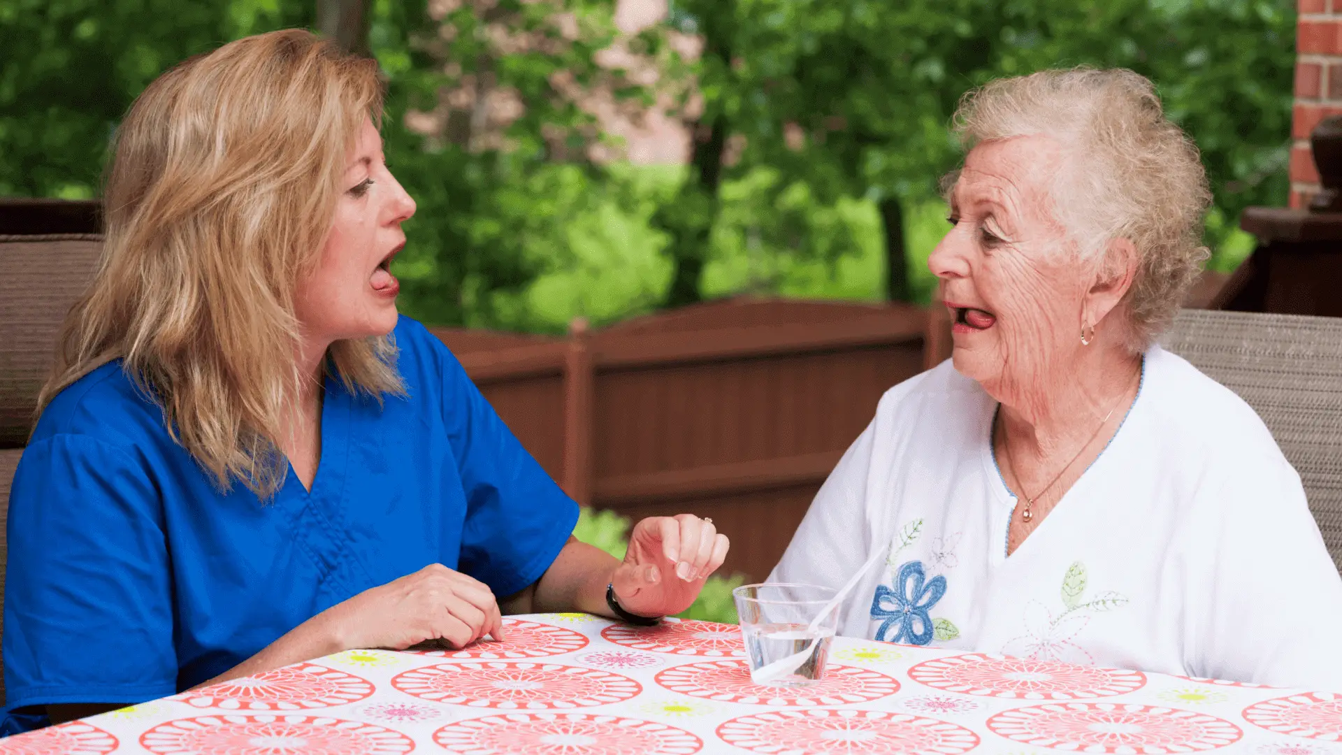 Woman assisting elderly woman in conversation outdoors.
