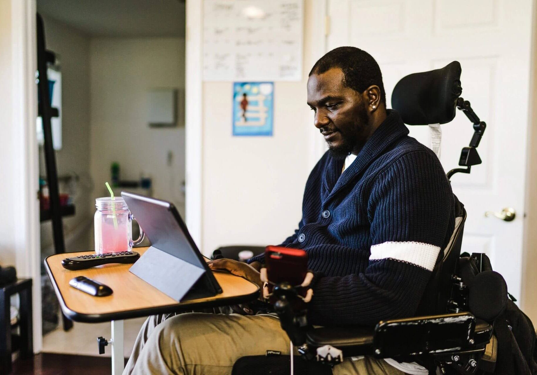 Man in motorized wheelchair working on laptop