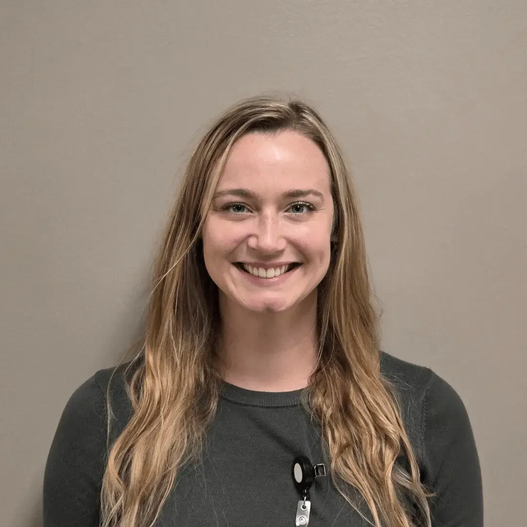 Smiling person with long, light brown hair.